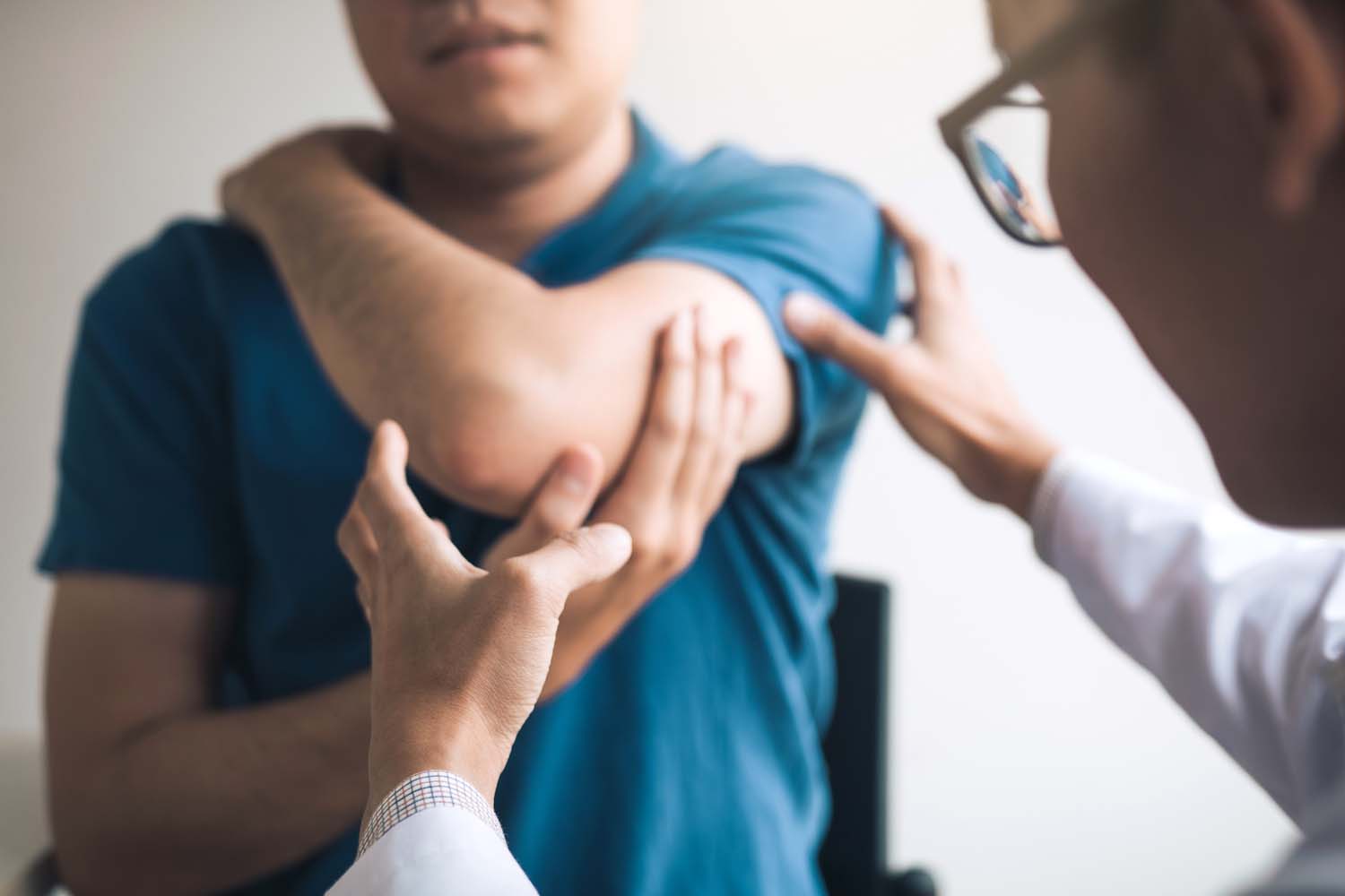 A doctor looking at a patient's elbow and shoulder