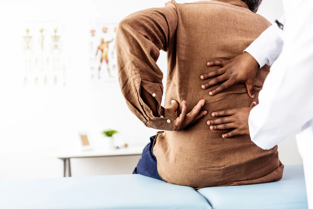 A doctor helping a patient with back pain