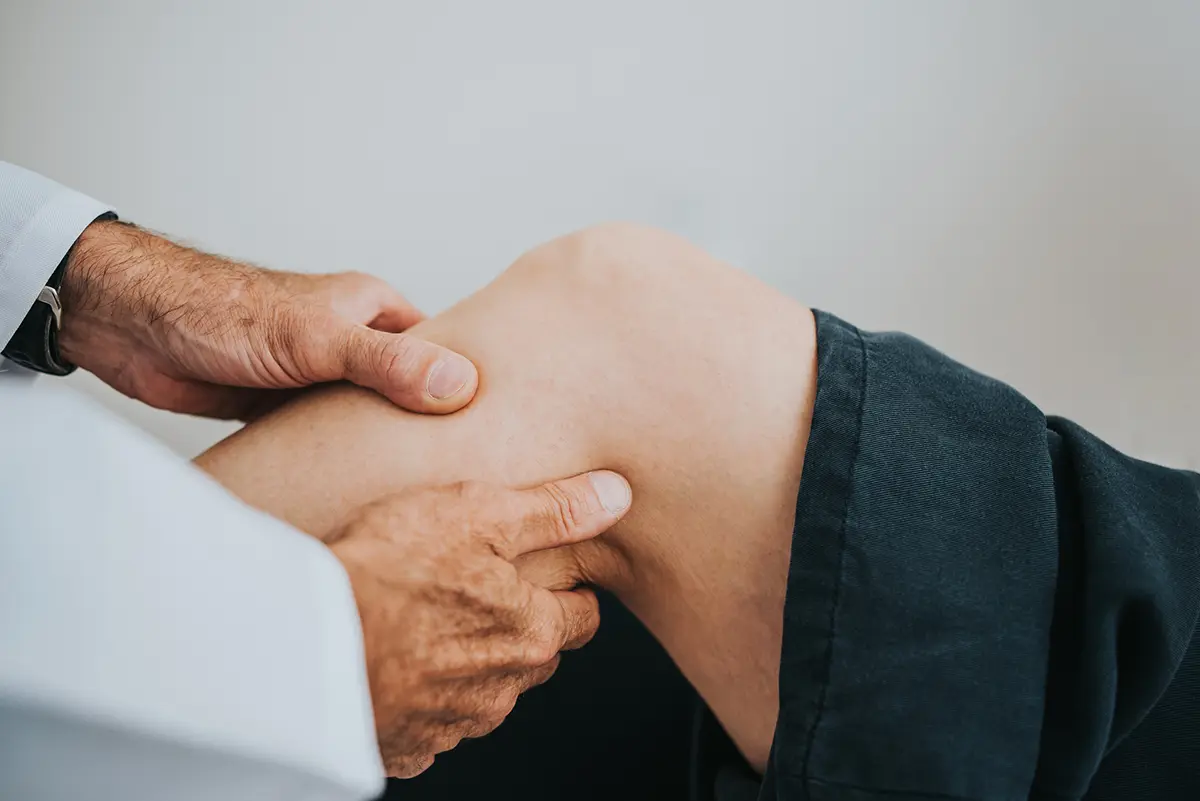 A doctor looking at a patient's knee